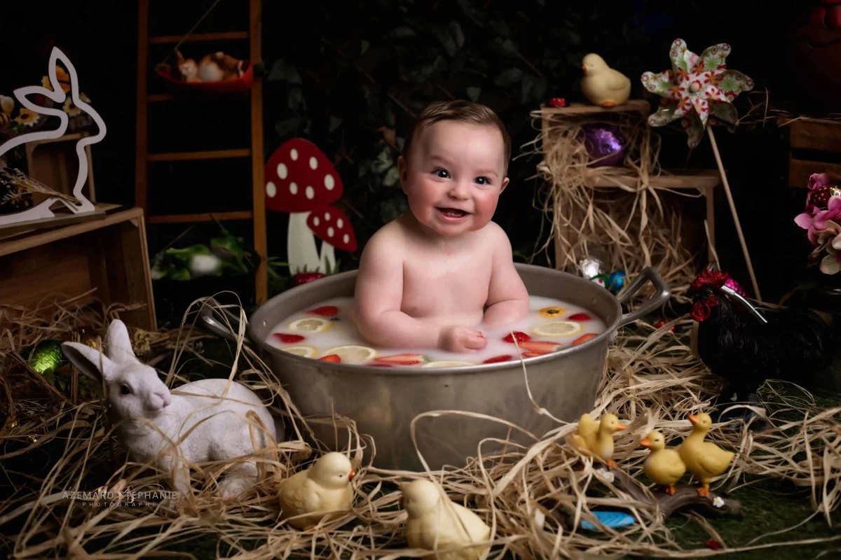 Photo bébé souriant dans un bain de lait décor Pâques studio avec lapin et poussins, photographe maternité Montpellier Stéphanie Azémard