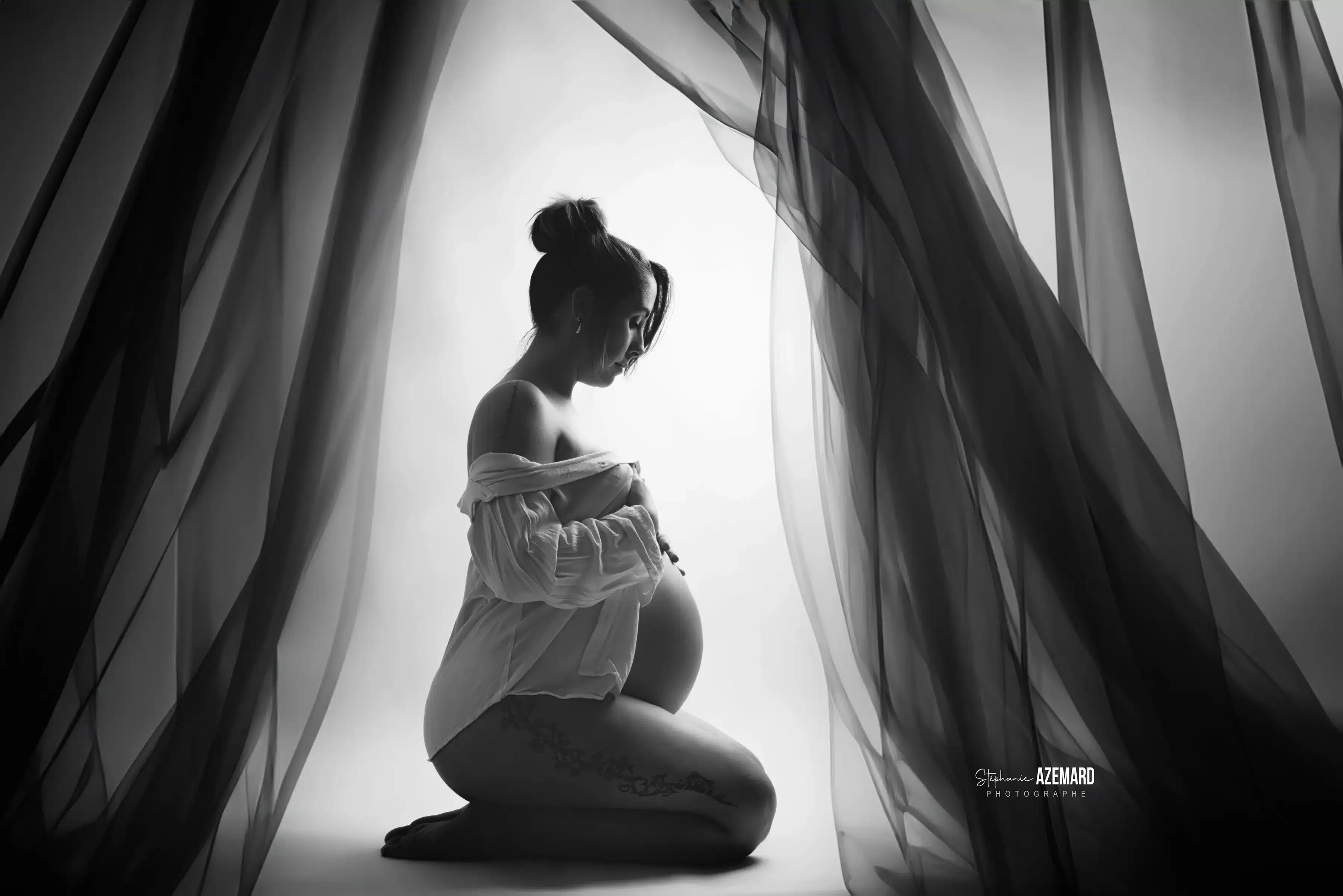 Séance photo grossesse silhouette agenouillée entre voiles noir et blanc studio — Stéphanie Azémard photographe maternité Montpellier