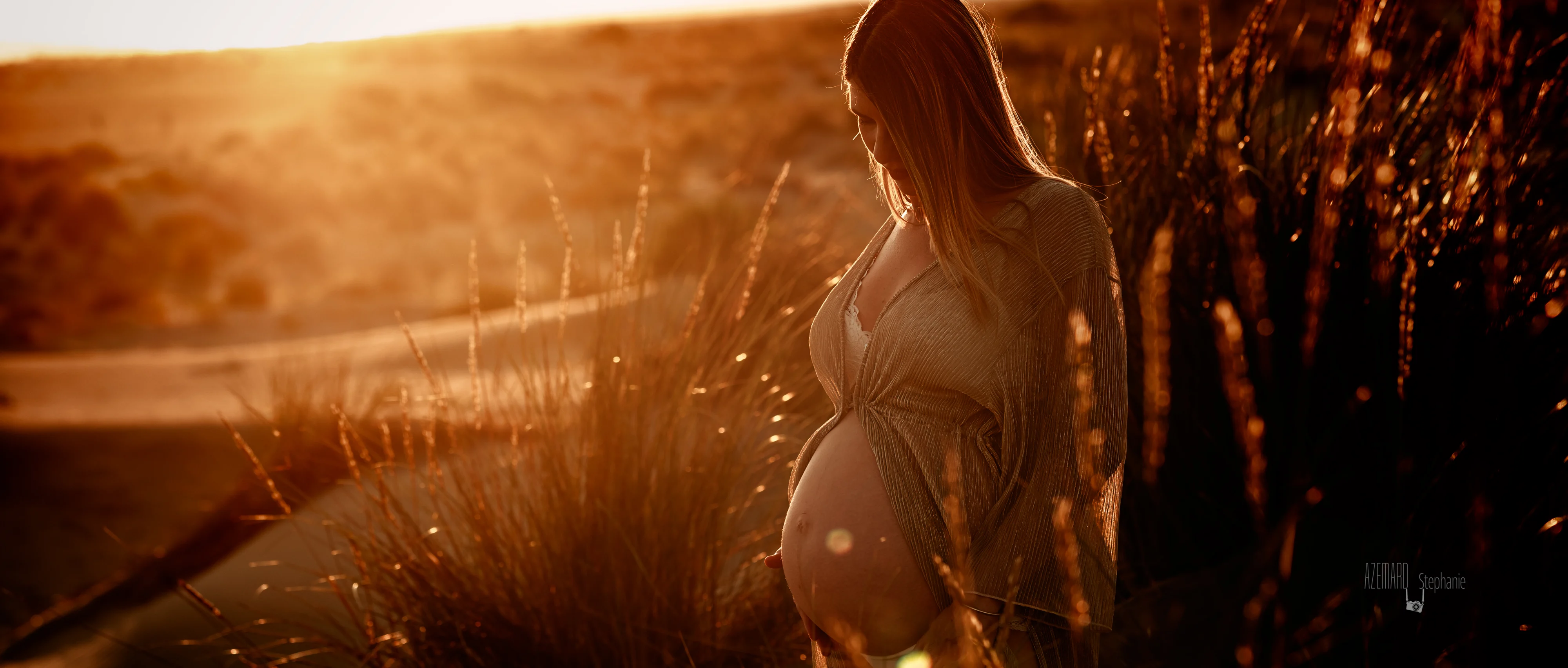Femme enceinte en lumière dorée au coucher du soleil lors d'une séance photo grossesse extérieur à Montpellier