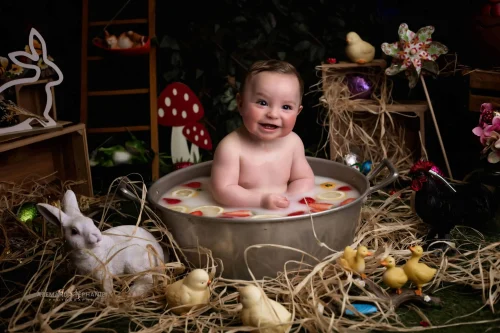 © Stéphanie Azémard — Photographe maternité Montpellier Photo bébé souriant dans un bain de lait décor Pâques studio avec lapin et poussins, photographe maternité Montpellier Stéphanie Azémard