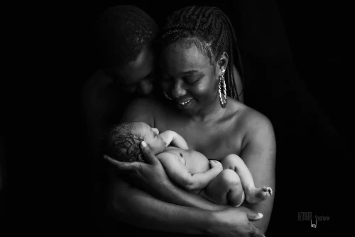 © Stéphanie Azémard — Photographe maternité Montpellier Photo famille parents souriants tenant leur nouveau-né en noir et blanc studio fond noir, photographe maternité Montpellier Stéphanie Azémard