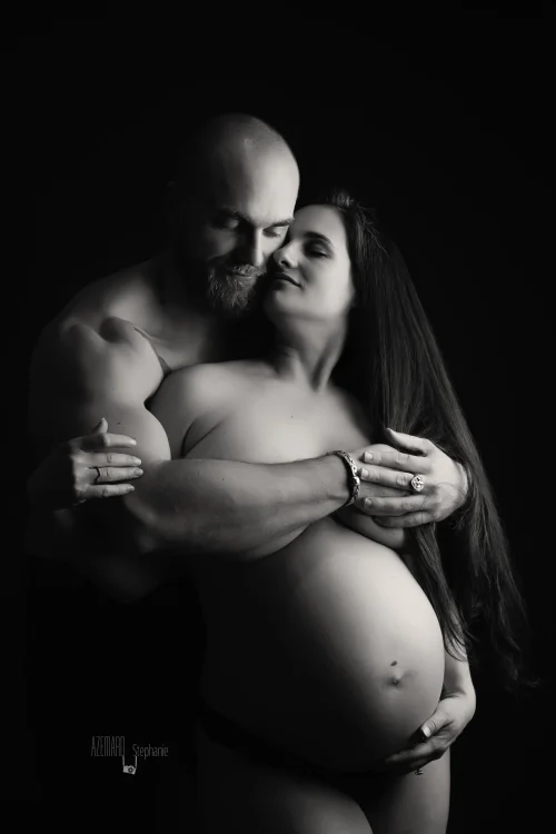 © Stéphanie Azémard — Photographe maternité Montpellier Photo grossesse couple enlacé papa entourant tendrement la future maman en noir et blanc studio fond noir, photographe maternité Montpellier Stéphanie Azémard