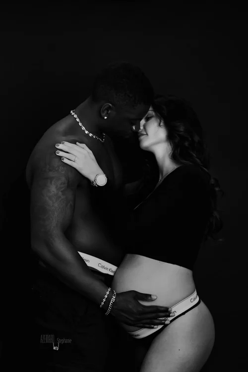 © Stéphanie Azémard — Photographe maternité Montpellier Photo grossesse couple tendresse papa tenant ventre future maman en noir et blanc studio fond noir, photographe maternité Montpellier Stéphanie Azémard