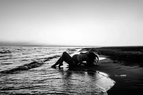 © Stéphanie Azémard — Photographe maternité Montpellier Photo grossesse future maman allongée au bord de l'eau sur la plage en noir et blanc coucher de soleil, photographe maternité Montpellier Stéphanie Azémard