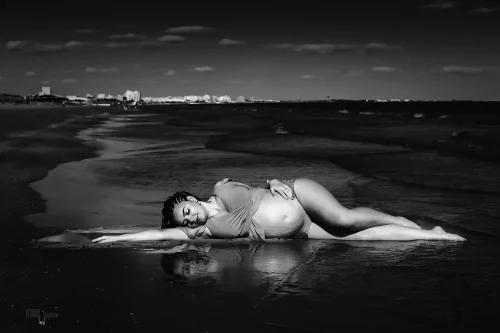 © Stéphanie Azémard — Photographe maternité Montpellier Photo grossesse future maman allongée dans l'eau au bord de mer en noir et blanc, photographe maternité Montpellier Stéphanie Azémard