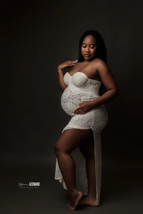 © Stéphanie Azémard — Photographe maternité Montpellier Portrait grossesse future maman robe dentelle blanche bustier appuyée sur tabouret en studio fond noir, photographe maternité Montpellier Stéphanie Azémard