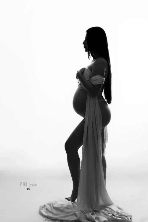 © Stéphanie Azémard — Photographe maternité Montpellier Photo grossesse silhouette future maman drapée tissu blanc de profil en noir et blanc fond blanc studio, photographe maternité Montpellier Stéphanie Azémard