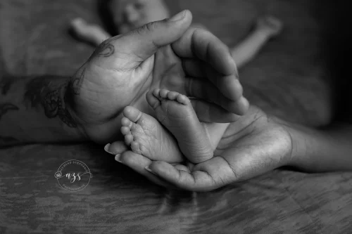 © Stéphanie Azémard — Photographe maternité Montpellier Photo pieds de bébé nouveau-né dans les mains des parents en noir et blanc, photographe maternité Montpellier Stéphanie Azémard