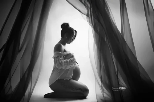 © Stéphanie Azémard — Photographe maternité Montpellier Séance photo grossesse silhouette agenouillée entre voiles noir et blanc studio — Stéphanie Azémard photographe maternité Montpellier