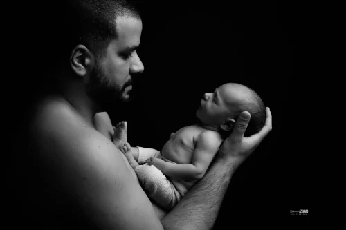 © Stéphanie Azémard — Photographe maternité Montpellier Séance photo nouveau-né papa mains regard tendre noir et blanc studio — Stéphanie Azémard photographe maternité Montpellier