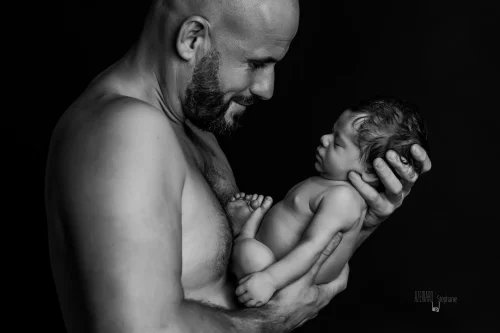 © Stéphanie Azémard — Photographe maternité Montpellier Séance photo nouveau-né papa souriant bras noir et blanc studio — Stéphanie Azémard photographe maternité Montpellier