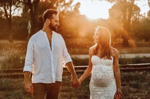 Séance grossesse golden hour — Stéphanie Azémard photographe maternité Montpellier Séance photo grossesse couple main dans la main au coucher du soleil golden hour, femme enceinte en robe dentelle blanche, photographe maternité Montpellier