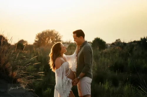 Couple en contre-jour doré dans les herbes des dunes