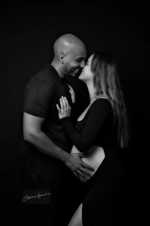 Couple nez à nez et souriant, séance grossesse en noir et blanc