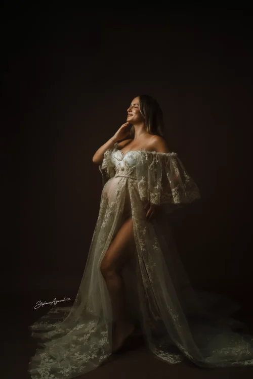 Portrait de femme enceinte en robe de dentelle à traîne, lumière studio