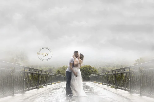 © Stéphanie Azémard — Photographe maternité Montpellier Photo grossesse couple qui s'embrasse sur un pont sous la pluie brume, future maman robe blanche, photographe maternité Montpellier Stéphanie Azémard