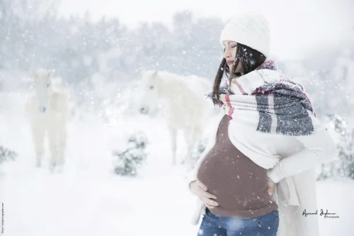 © Stéphanie Azémard — Photographe maternité Montpellier Photo grossesse future maman sous la neige avec cheval blanc en arrière-plan, photographe maternité Montpellier Stéphanie Azémard